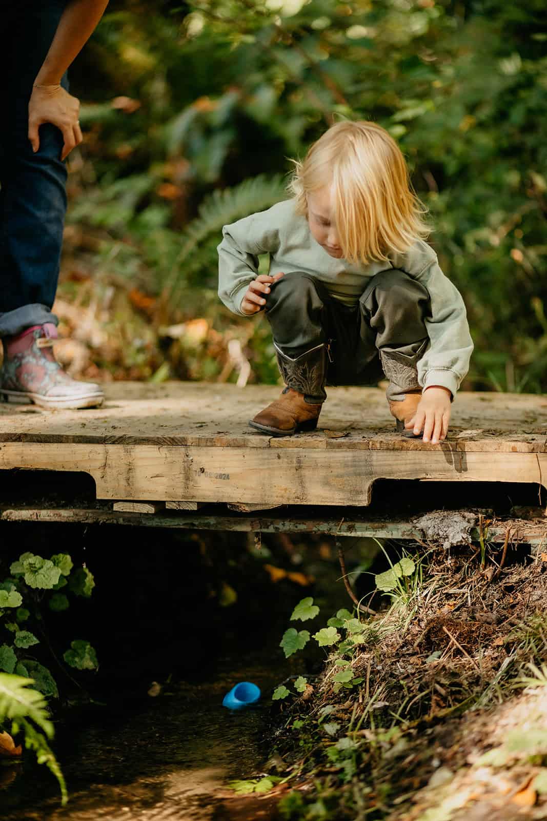 Child looking over small bridge at Hidden Meadow School