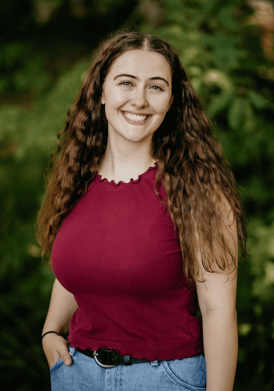 Molly Orear co-teacher at hidden meadow forest school olympia washington portrait of her standing in front of forest smiling