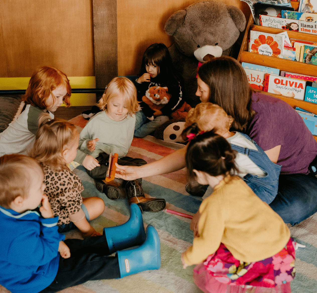 Forest school children with Molly Orear sitting on rug doing circle time