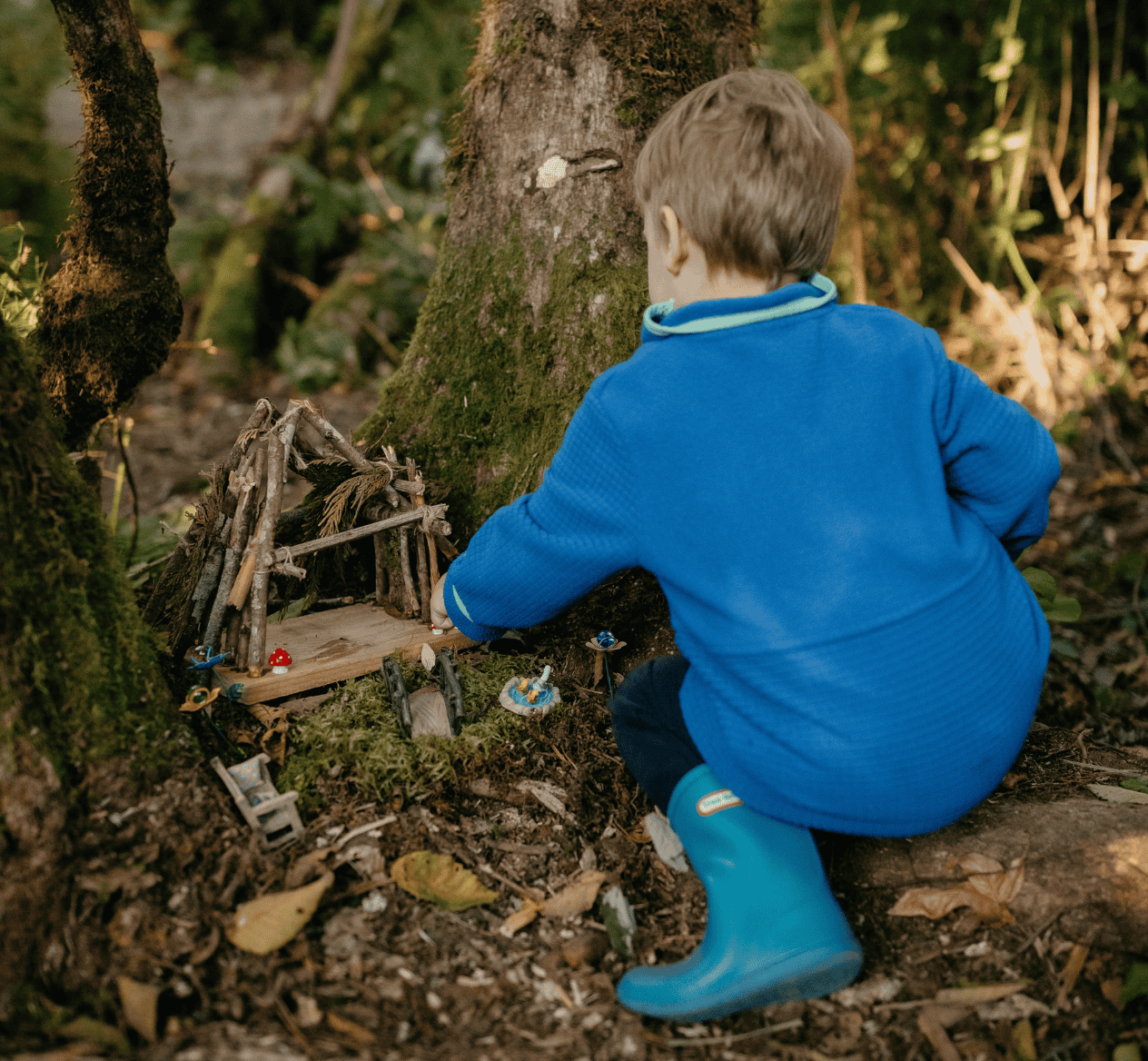 Child playing with fairy garden on forest trail at Hidden Meadow School