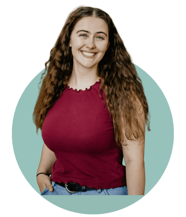 Dani Thompson smiling in front of blue circle
