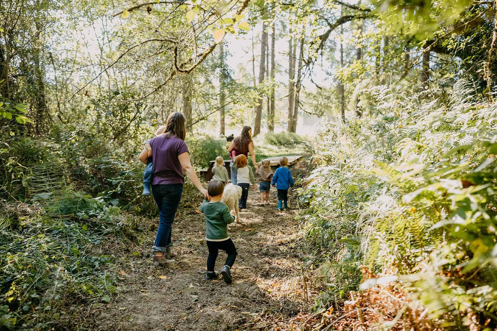 Molly Orear and students walking down forest trail at Hidden Meadow School