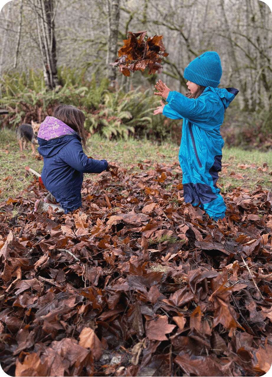 children playing in fall leaves