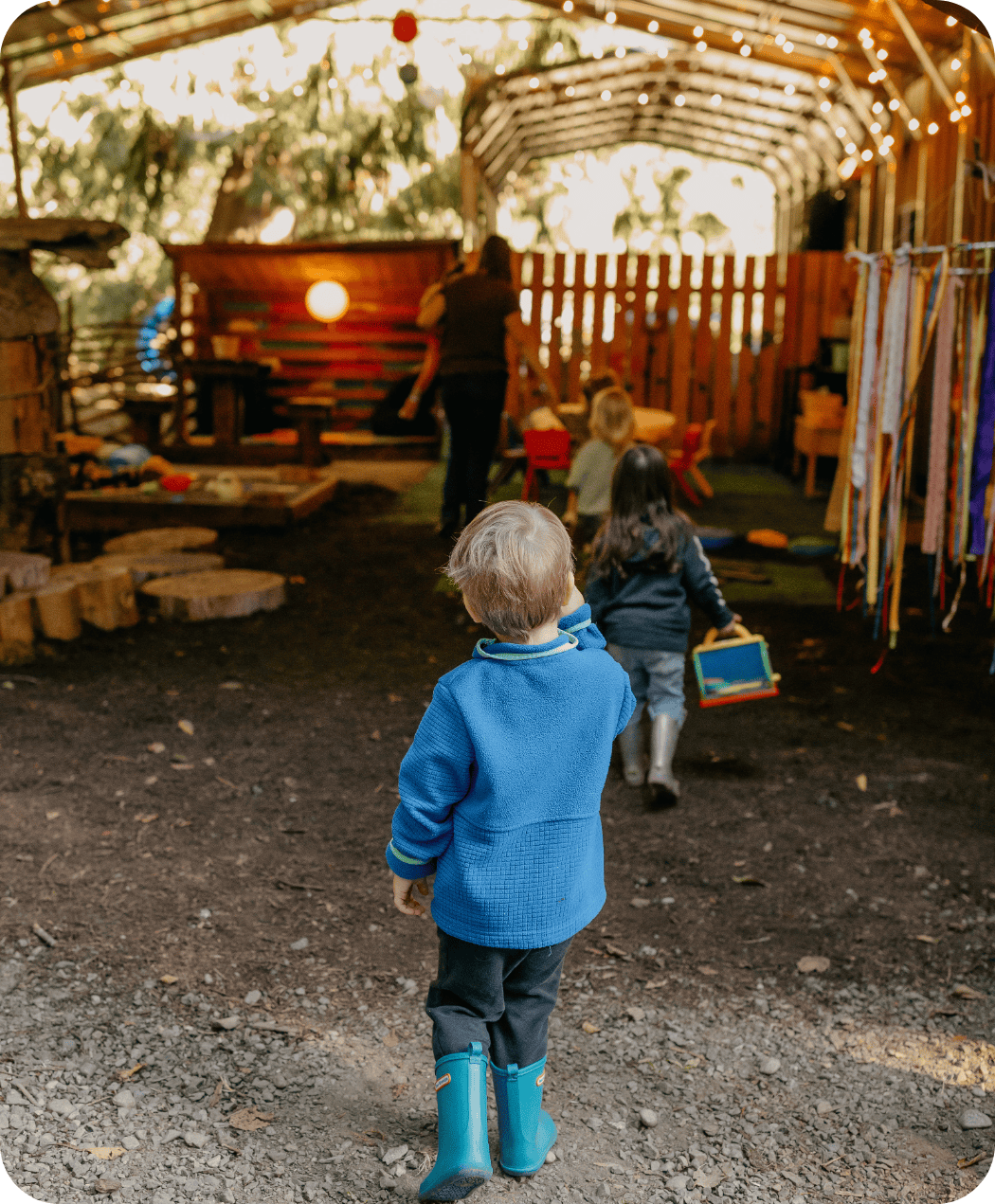 Children walking into covered structure at Hidden Meadow School