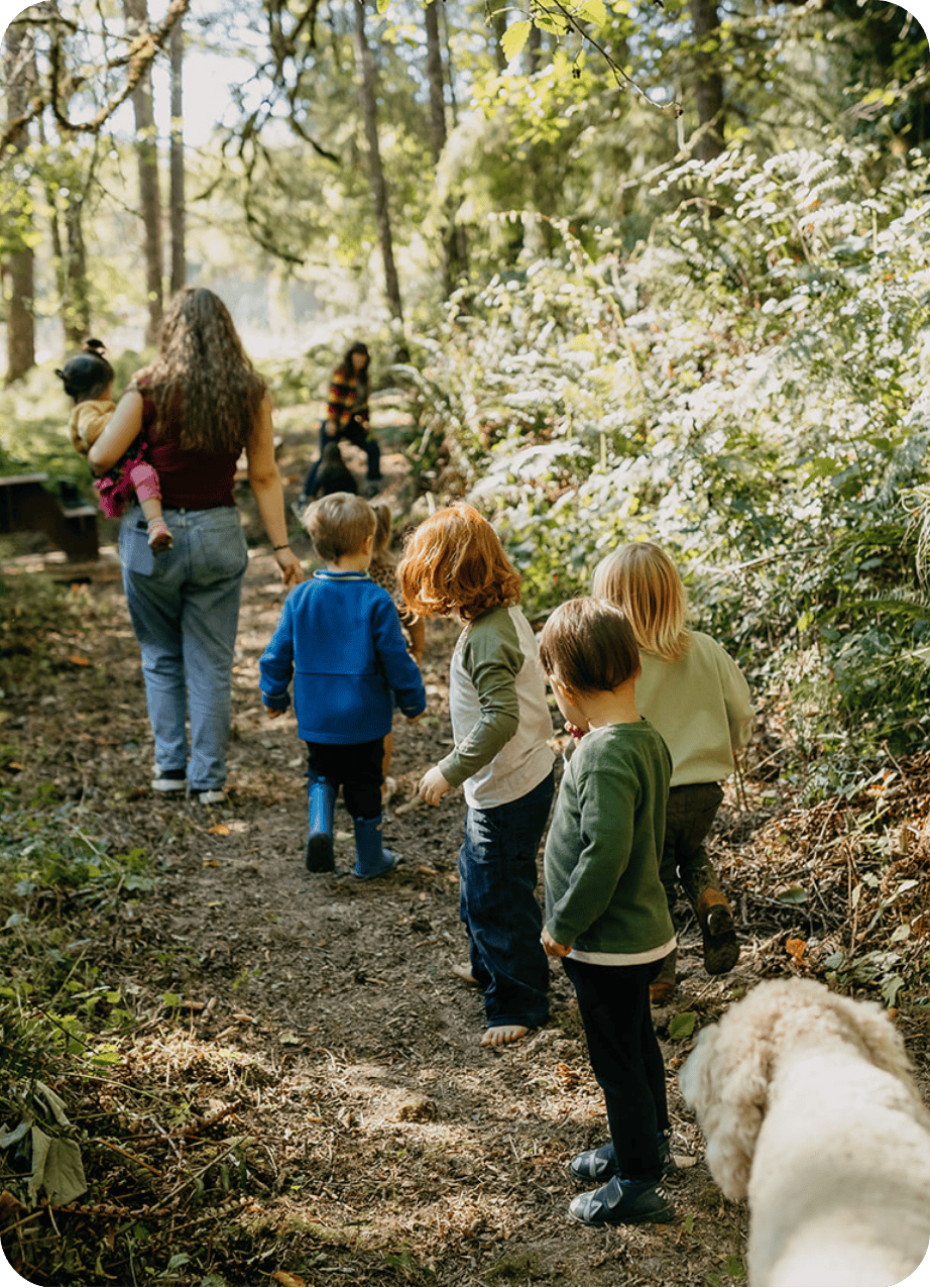 Forest school children walking in the forest at Hidden Meadow School