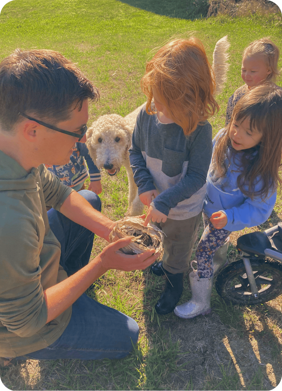 Jake showing children birds nest at Hidden Meadow School